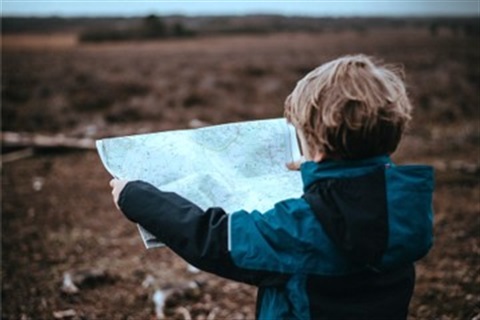 Child holding map outdoors scavenger hunt