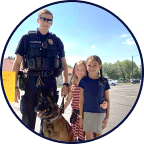 Police officer and K9 outdoors with children